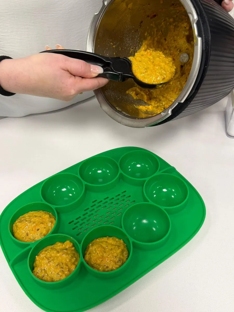 Teig wird bei einer Thermomix® Beratung von Hand aus dem Mixtopf in die Silikonform portioniert