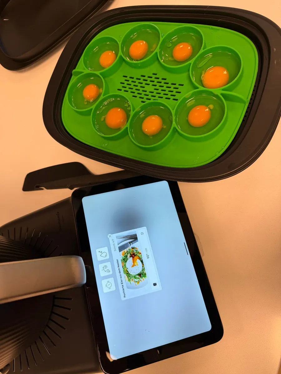 Pochierte Eier im Eier-Einsatz des Thermomix® TM7, das Display zeigt das geführte Rezept